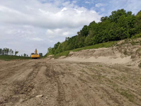 A construction site with a large excavator is right beside a Bank Swallow nesting colony.